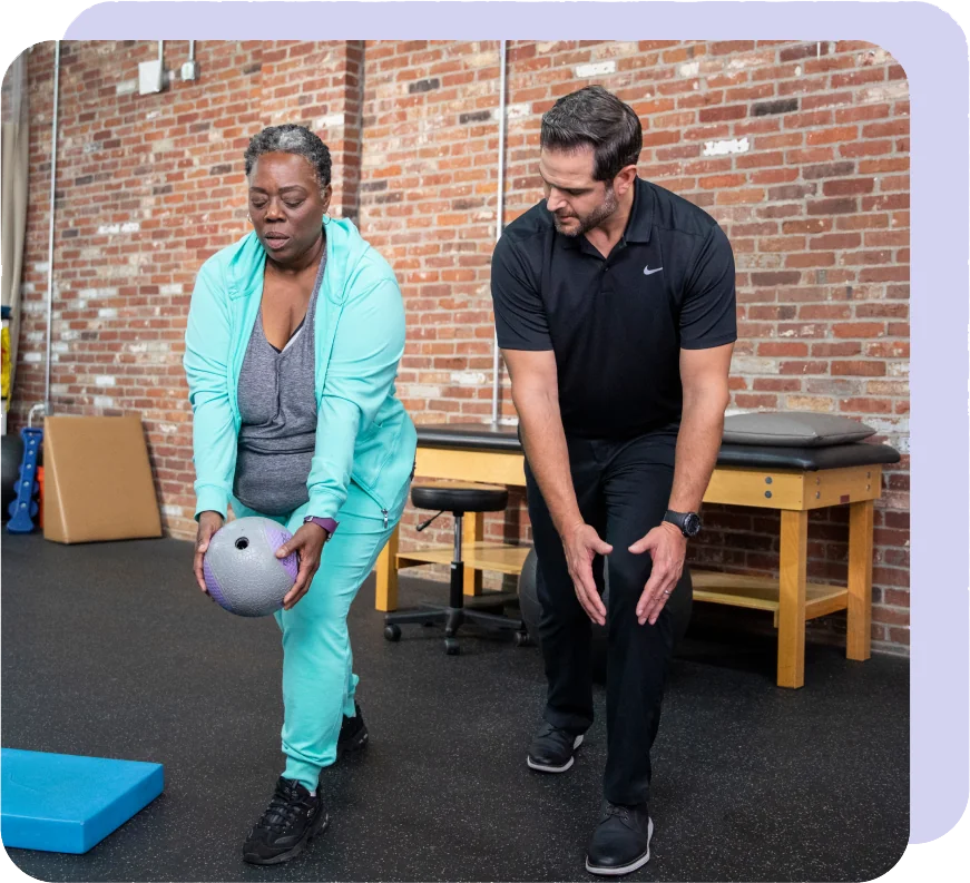 Leading-The-Way woman in a teal jumpsuit doing medicine ball exercises